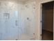 Modern glass shower featuring marble-style tile and a walk-in closet at 452 Eagles Nest Cir, Auburn, GA 30011
