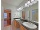 Spacious bathroom featuring dual sinks with granite countertops, with a view to an office at 5780 Warren Farm Sw Rd, Powder Springs, GA 30127