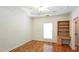 Bright bedroom featuring hardwood floors, built-in shelving, and a tray ceiling at 5780 Warren Farm Sw Rd, Powder Springs, GA 30127