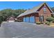 Exterior view of the house showing a three car garage and additional garage space with a large parking area at 5780 Warren Farm Sw Rd, Powder Springs, GA 30127