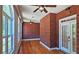 Enclosed sunroom with brick walls, hardwood floors, and multiple windows for natural light at 5780 Warren Farm Sw Rd, Powder Springs, GA 30127