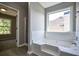 Relaxing bathroom featuring a soaking tub, tiled walls, and a large window at 907 Southfork Dr, Loganville, GA 30052