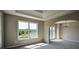 Bright living room with tray ceiling, chandelier, large windows overlooking green landscape at 907 Southfork Dr, Loganville, GA 30052