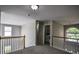 Upstairs landing area featuring railing and natural light, with nearby doorways at 907 Southfork Dr, Loganville, GA 30052