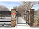 Gated community entrance with stone pillars and black metal gate provides security and privacy for residents at 130 Arizona Ne Ave # 106, Atlanta, GA 30307