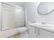 A well-lit bathroom features a shower, toilet, white vanity, and sleek round mirror at 2660 Burnstone Run, Lawrenceville, GA 30044