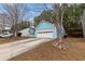 Light blue home with a two-car garage and a concrete driveway nestled in a wooded area at 2660 Burnstone Run, Lawrenceville, GA 30044