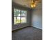 Inviting bedroom features neutral carpet, a ceiling fan, and a large window for natural light at 500 Kings Pl, Riverdale, GA 30296