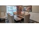 Elegant dining room featuring a large wood table, upholstered chairs, and natural light from the window at 726 Fraser Ct, Mcdonough, GA 30253