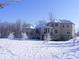 Exterior of home covered in snow with rear covered patios and sunlit snowy trees at 1069 Eagles Brooke Dr, Locust Grove, GA 30248