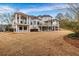 Expansive backyard featuring multi-story balconies, a large lawn, and mature trees at 1069 Eagles Brooke Dr, Locust Grove, GA 30248