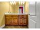 Bathroom featuring a double sink vanity, tiled floors, a large mirror, and a white door at 1069 Eagles Brooke Dr, Locust Grove, GA 30248