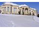 Elegant stucco home featuring arched entryway, manicured bushes and snow covered front yard at 1069 Eagles Brooke Dr, Locust Grove, GA 30248