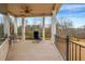 Covered patio with seating and railing, offering views of the wooded backyard at 1069 Eagles Brooke Dr, Locust Grove, GA 30248