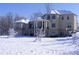 Back of elegant home showcasing covered patios, multiple windows, and snow-covered landscape at 1069 Eagles Brooke Dr, Locust Grove, GA 30248