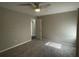 Bedroom with neutral walls and carpet, featuring a ceiling fan and a view into the hall at 1454 Walnut Log Pl, Austell, GA 30168