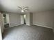 Large, carpeted bedroom with a ceiling fan and views into the hall and closet at 1454 Walnut Log Pl, Austell, GA 30168