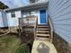 Inviting front entrance to the blue sided home with stairs leading to a small, charming wooden deck at 1454 Walnut Log Pl, Austell, GA 30168