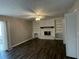 Living room featuring a fireplace with white brick surround, built-in shelves, and wood-look flooring at 1454 Walnut Log Pl, Austell, GA 30168