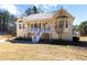 Charming yellow home features a welcoming front porch with white railing and a well-manicured lawn at 151 Berkshire Dr, Hiram, GA 30141