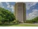 Stunning high-rise apartment building with manicured lawn and mature trees on a partly cloudy day at 1501 Clairmont Rd # 1318, Decatur, GA 30033