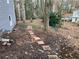 Backyard landscaping with a brick pathway, mature trees, and partial views of neighboring homes at 5073 Willow Point Pkwy, Marietta, GA 30068