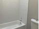 Clean bathroom featuring tiled shower/tub, with white fixtures and hardware and a standard toilet at 5073 Willow Point Pkwy, Marietta, GA 30068