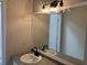 Modern bathroom featuring a granite-style countertop, a large mirror with accent lighting, and sleek hardware at 5073 Willow Point Pkwy, Marietta, GA 30068