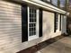 Exterior detail of home with neutral siding and black shutters on windows at 5073 Willow Point Pkwy, Marietta, GA 30068