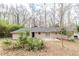 Back exterior view featuring a brick ranch-style home with a patio and mature trees at 5130 Cornwallis Ct, Stone Mountain, GA 30088