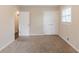 This bedroom features neutral walls, plush carpeting, a window and a closet for ample storage at 5130 Cornwallis Ct, Stone Mountain, GA 30088