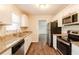 This kitchen features stainless steel appliances, wood floors, granite countertops, and white cabinetry at 5130 Cornwallis Ct, Stone Mountain, GA 30088