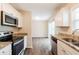 This kitchen features stainless steel appliances, wood floors, granite countertops, and white cabinetry at 5130 Cornwallis Ct, Stone Mountain, GA 30088