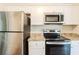 This kitchen features stainless steel appliances, granite countertops and white cabinetry at 5130 Cornwallis Ct, Stone Mountain, GA 30088