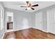 Bedroom featuring hardwood floors, ceiling fan, and a view into the bathroom at 5555 Woodland Dr, Douglasville, GA 30135