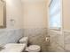 This bathroom showcases marble tile accents, a modern vanity, and a window at 8673 Chestnut Ln, Lithia Springs, GA 30122