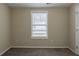 Neutral bedroom with carpeting, window with blinds, and white door leading to other rooms at 8673 Chestnut Ln, Lithia Springs, GA 30122