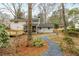 Spacious backyard featuring a stone pathway, screened porch, and mature trees at 1509 Diamond Head Dr, Decatur, GA 30033