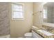 Bathroom with granite countertop, tiled shower with marble-style details, and a window at 3499 Villa Se Cir, Atlanta, GA 30354