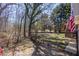 View of the backyard with trees, fencing, and a small wooden deck with stairs at 255 N Loblolly Xing, Temple, GA 30179