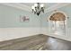 Dining room with arched window, wood floors, wainscoting, and chandelier at 559 Fairway Dr, Woodstock, GA 30189