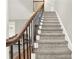 Carpeted staircase featuring elegant wood and iron railings leading to the upper level of the home at 559 Fairway Dr, Woodstock, GA 30189