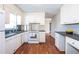 Bright kitchen featuring white appliances and cabinets, dark countertops, and hardwood floors at 202 Porter Ln, Jonesboro, GA 30236