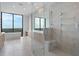 Bright bathroom features a glass-enclosed shower, soaking tub, and large windows with beautiful outdoor views at 2425 Peachtree Rd # 1806, Atlanta, GA 30305