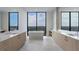 Modern bathroom featuring dual vanities, a soaking tub, and a large window with a view at 2425 Peachtree Rd # 1806, Atlanta, GA 30305