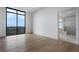 Sunlit bedroom features wood floors, a large window, and an ensuite bathroom with a glass shower at 2425 Peachtree Rd # 1806, Atlanta, GA 30305