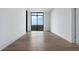 Bright bedroom with hardwood floors, white walls, and a large window overlooking a wooded area at 2425 Peachtree Rd # 1806, Atlanta, GA 30305