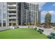 Spacious dog park with artificial turf and benches, set against the backdrop of a modern condominium building at 2425 Peachtree Rd # 1806, Atlanta, GA 30305