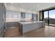 Modern kitchen with gray cabinets, a large island, stainless appliances, and a city view at 2425 Peachtree Rd # 1806, Atlanta, GA 30305