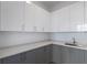 Bright modern kitchen with gray lower and white upper cabinets, stainless sink and quartz countertops at 2425 Peachtree Rd # 1806, Atlanta, GA 30305